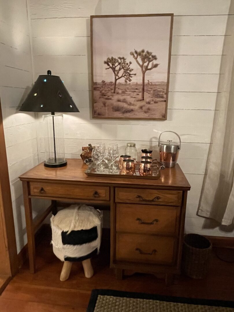 A desk with a lamp and a picture on the wall