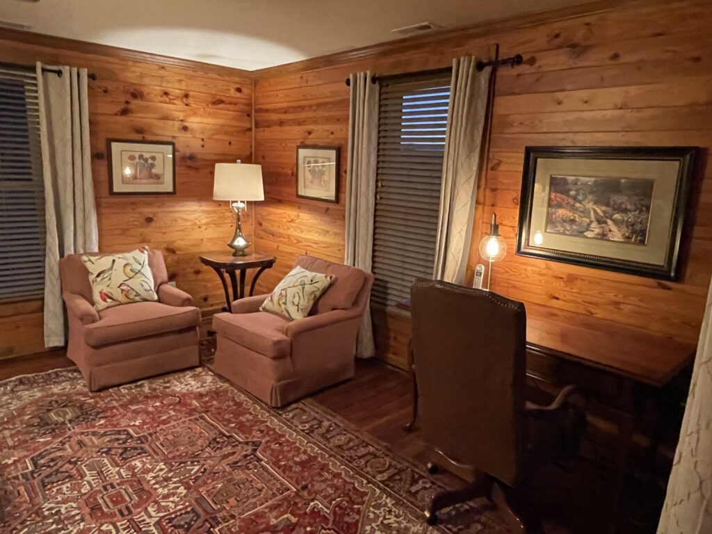 A living room with wood paneled walls and furniture.