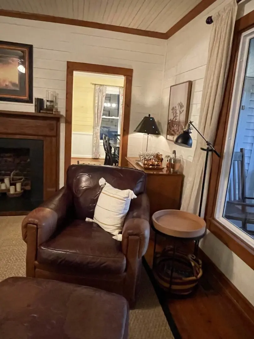 A living room with a fireplace and leather chair