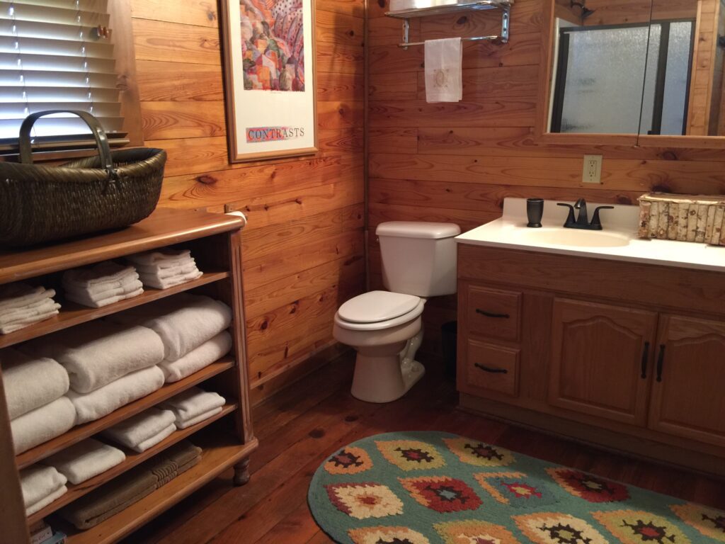 A bathroom with wood paneling and wooden floors.